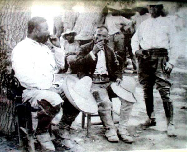 On the left, Jose Doroteo Arango Arámbula, “Pancho Villa”, enjoying a marijuana cigarette